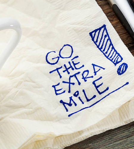 go the extra mile - motivational slogan on a napkin with a cup of coffee
